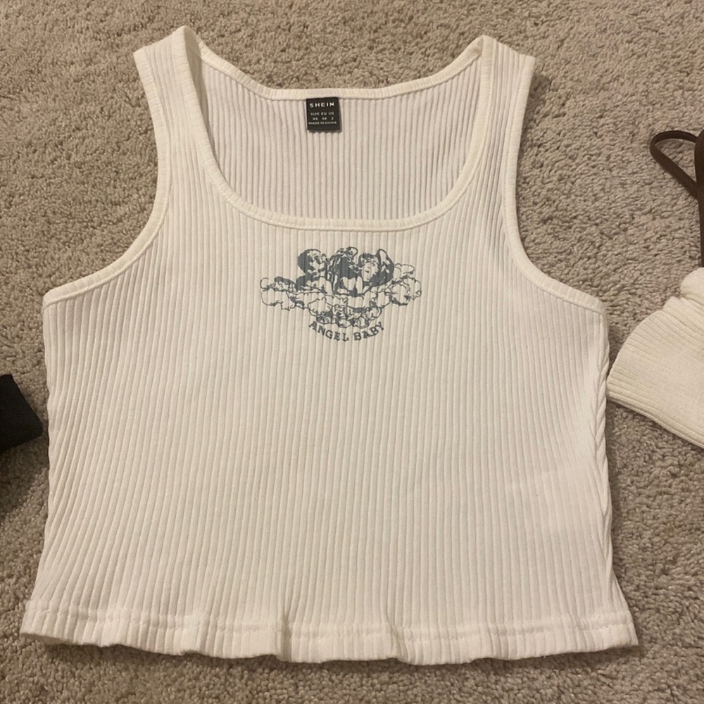 White crop top that says “Angel baby”